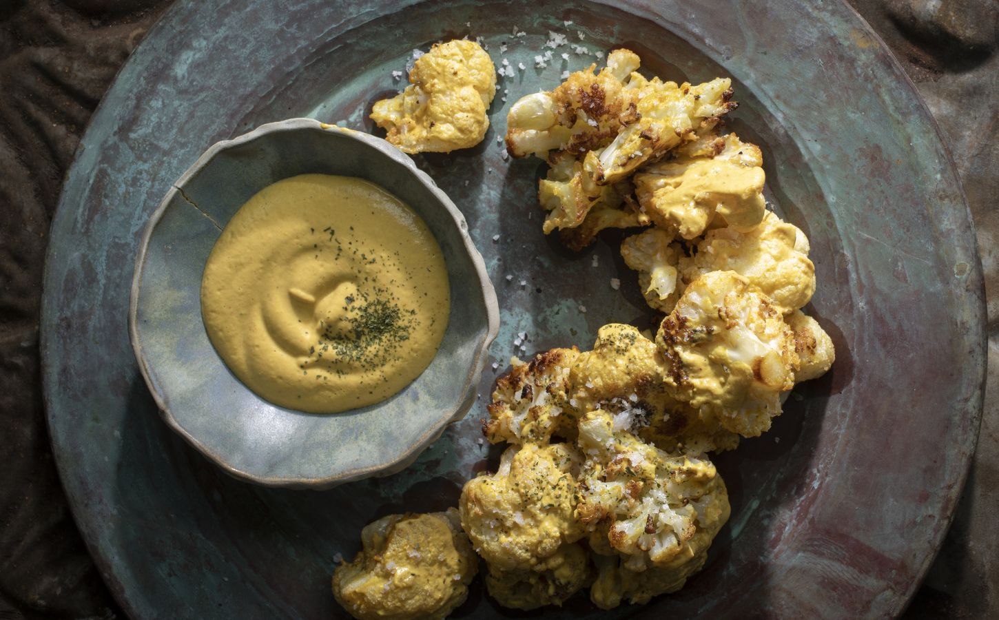 a picture of coliflor frito or crispy cauliflower served with cashew nacho cheese