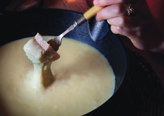 bread dipped in a creamy alpine fondue that is vegan