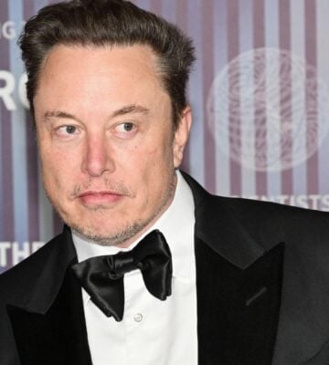 Elon Musk wearing a suit on a red carpet