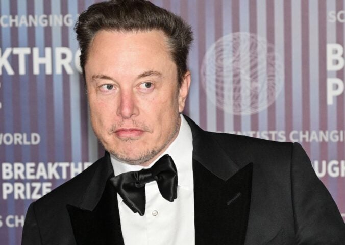 Elon Musk wearing a suit on a red carpet