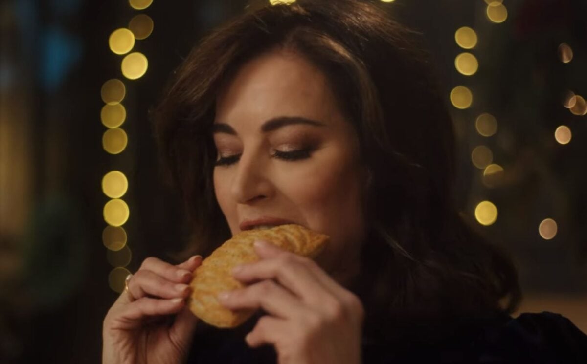 Photo shows Nigella Lawson taking a bite of a Greggs Festive Bake, which is also available as a vegan menu item