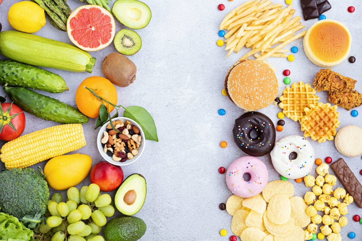 Photo shows a selection of nutrient-dense fresh fruit, vegetables, and nuts on the left and less nutritious foods like doughnuts, cakes, and waffles on the right