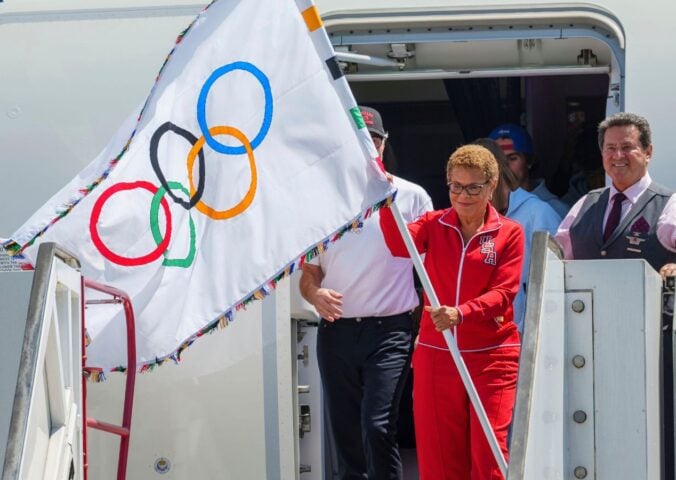 Los Angeles Mayor Karen Bass holds the official Olympic flag at Los Angeles International Airport