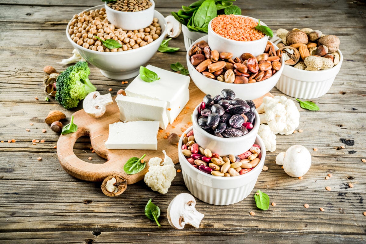 Photo shows dishes and platters of several sources of plant-based protein, including tofu, beans, nuts, and more