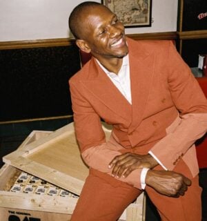 A photo of British rapper Giggs sitting on a crate of Oatly cartons