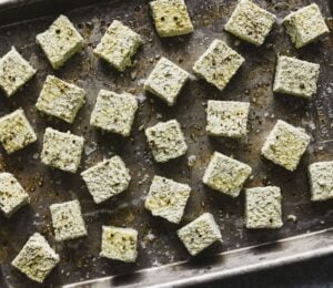 a tray of seasoned pumpkin seed tofu cubes