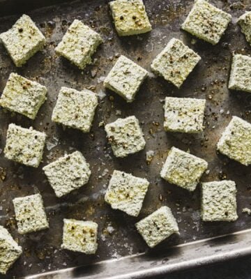 a tray of seasoned pumpkin seed tofu cubes