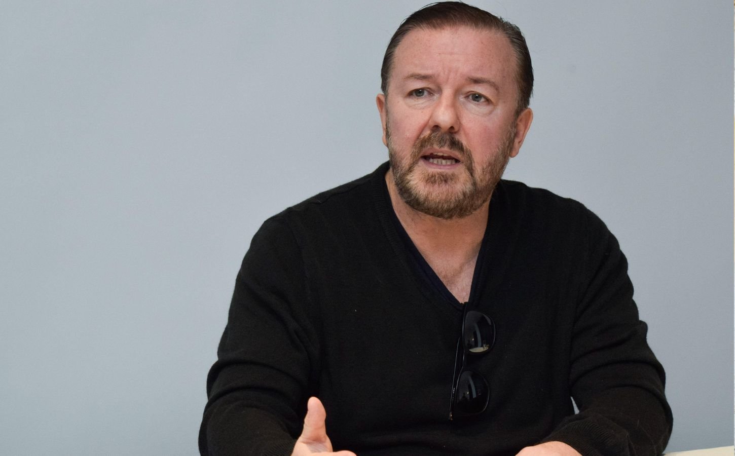 Vegan celebrity Ricky Gervais in front of a gray background