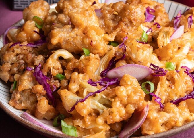 a plate of fried sweet and sour cauliflower with garnish