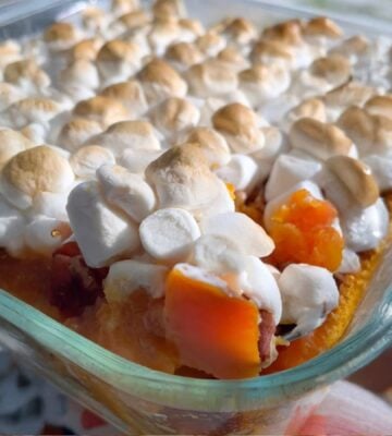 A dish full of sweet potato casserole with marshmallows