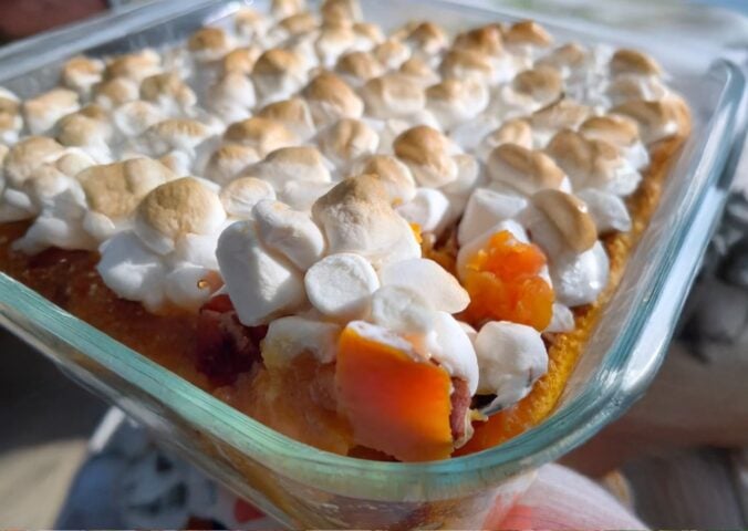 A dish full of sweet potato casserole with marshmallows