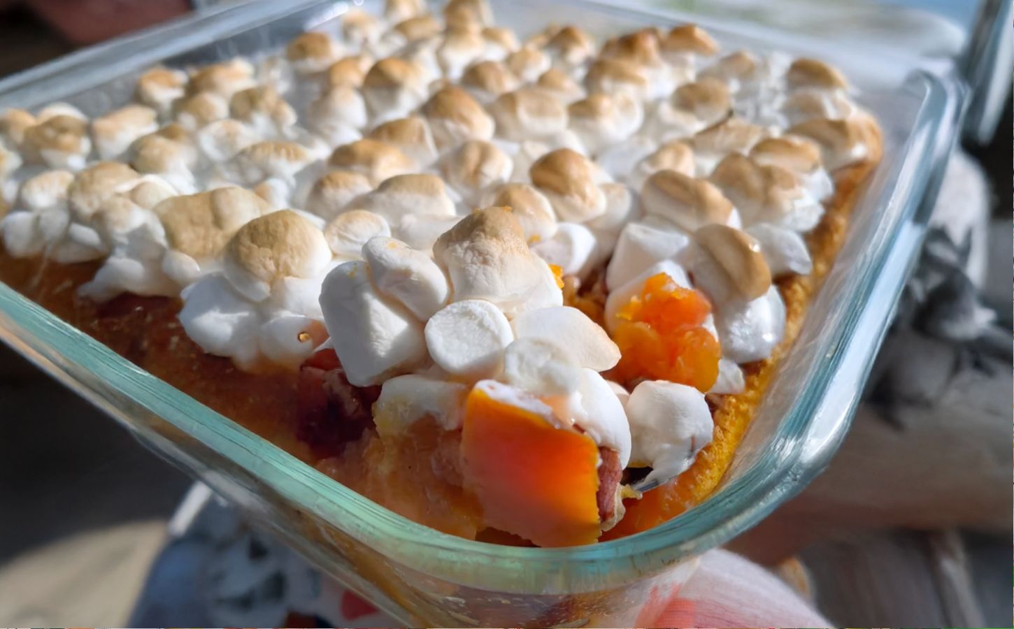 A dish full of sweet potato casserole with marshmallows