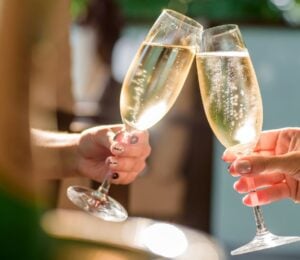 Two people clinking champagne glasses together