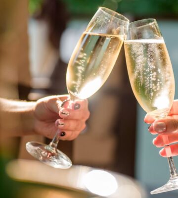 Two people clinking champagne glasses together