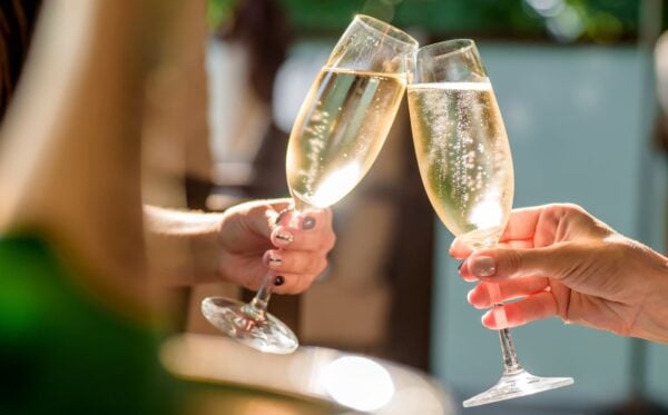 Two people clinking champagne glasses together