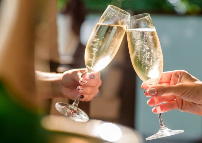 Two people clinking champagne glasses together