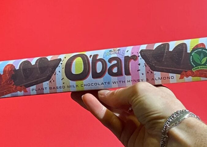 A hand holding up a Toblerone-style vegan bar named O'Bar from Catherine's Originals