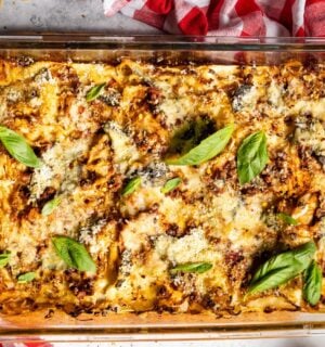 a baked cabbage and walnut lasagna in a dish with basil on top