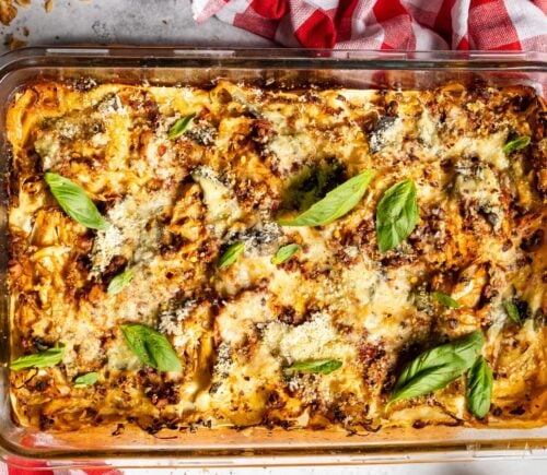 a baked cabbage and walnut lasagna in a dish with basil on top