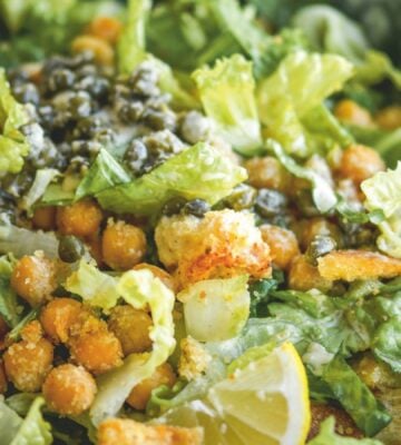 a bowl of vegan chickpea Caesar salad with chickpeas, capers, lemon, and croutons