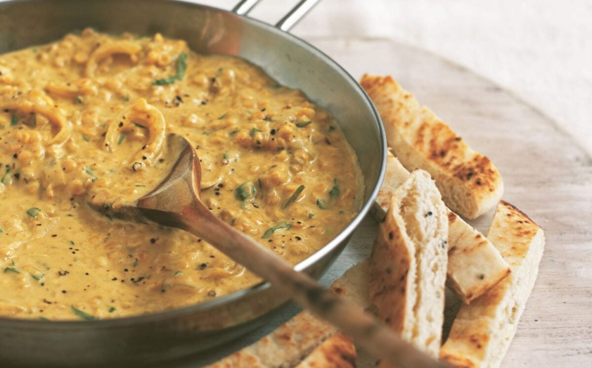 a pan of coconut dhal with toasted naan fingers on the side