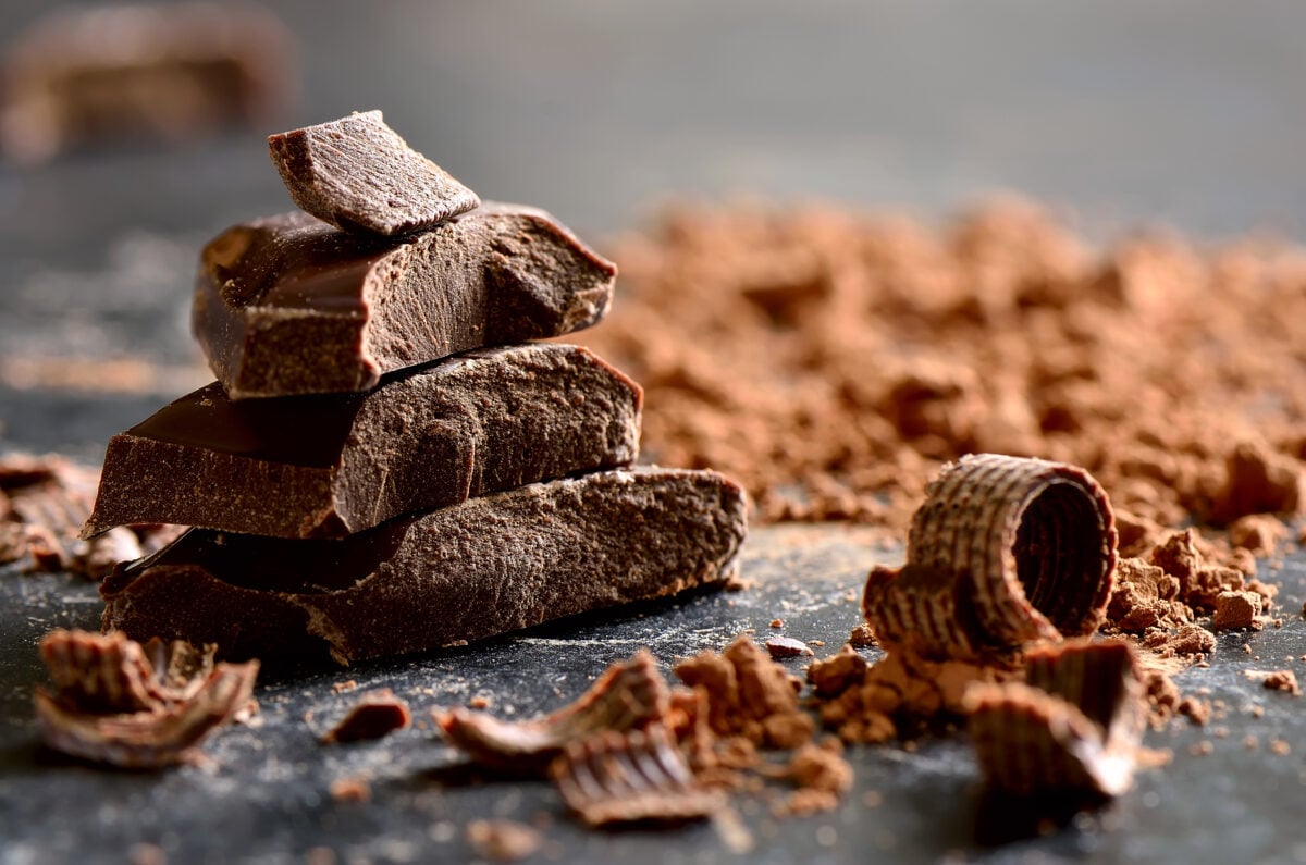 A pile of dark chocolate on a gray surface