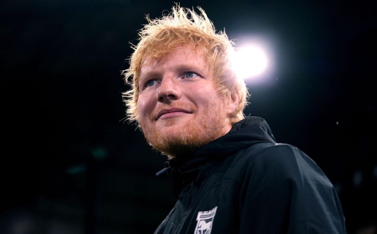 Singer Ed Sheeran looking past the camera in front of a black background