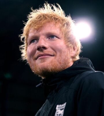 Singer Ed Sheeran looking past the camera in front of a black background
