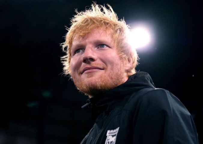 Singer Ed Sheeran looking past the camera in front of a black background