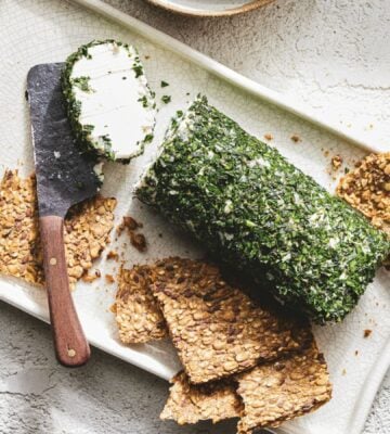 a picture of a log of vegan goat-style cheese rolled in herbs