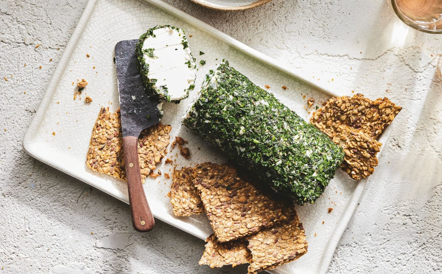 a picture of a log of vegan goat-style cheese rolled in herbs