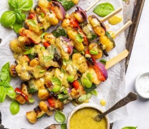 a tray of grilled gnocchi skewers with basil dip