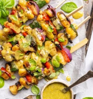 a tray of grilled gnocchi skewers with basil dip