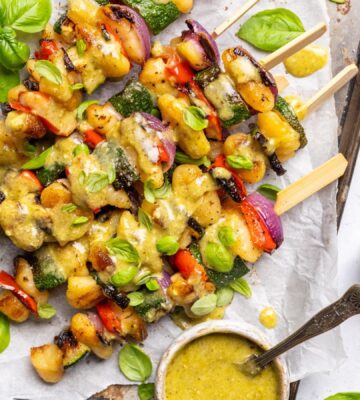 a tray of grilled gnocchi skewers with basil dip