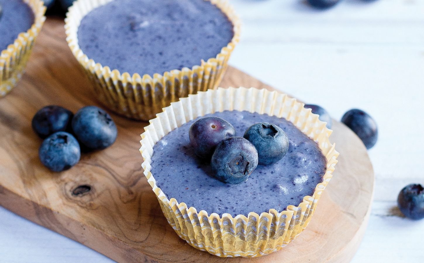 a picture of two mini blueberry cheesecakes with blueberries for decoration