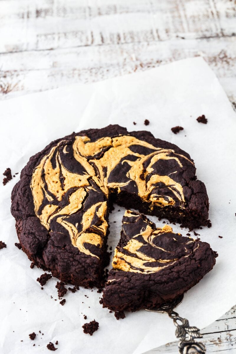 a mini brownie tart with peanut almond cream swirl with a slice cut out