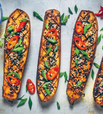 a picture of four miso caramel eggplant pieces garnished with scallion and chili