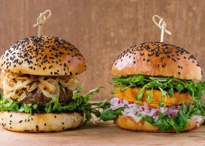 Photo shows a traditional meat-based burger (left) and a plant-based burger (right) side by side