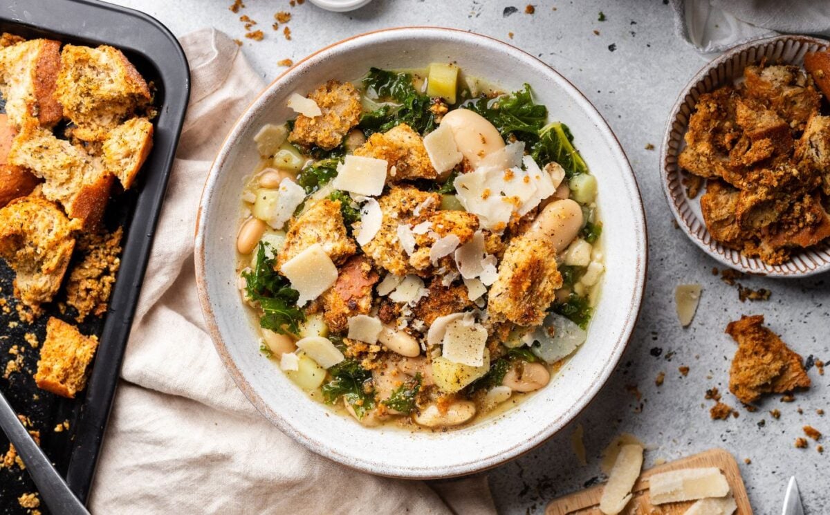 a bowl of rustic white bean and kale soup with homemade croutons