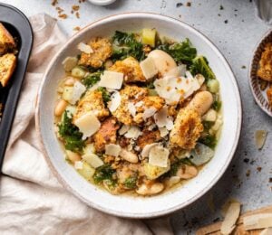 a bowl of rustic white bean and kale soup with homemade croutons