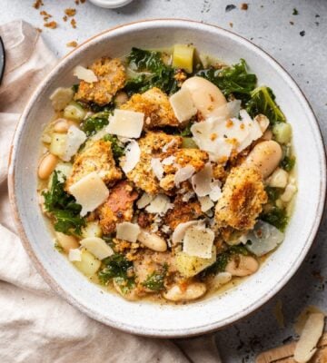 a bowl of rustic white bean and kale soup with homemade croutons