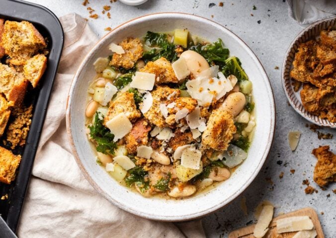 a bowl of rustic white bean and kale soup with homemade croutons