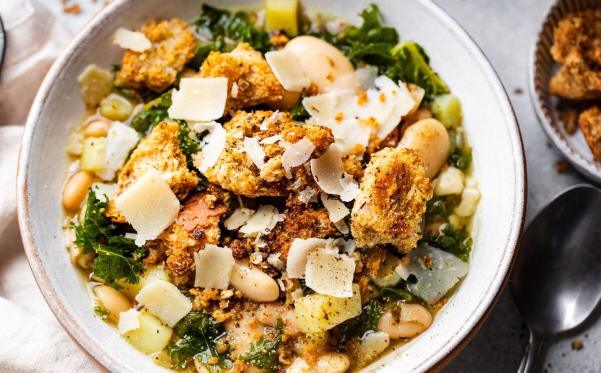 a bowl of rustic white bean and kale soup with homemade croutons