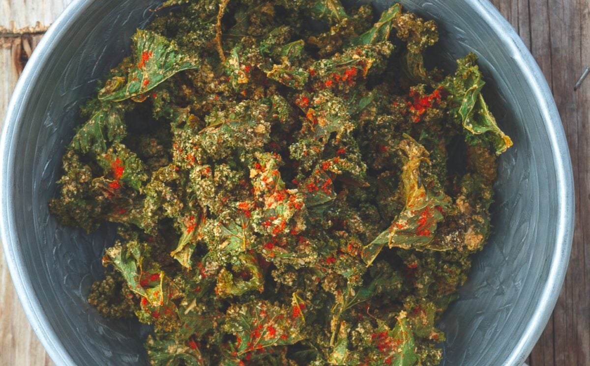 a bowl of savory kale chips with cashews, paprika, lemon, nutritional yeast