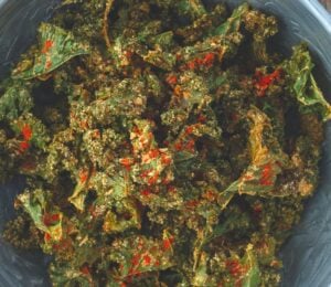 a bowl of savory kale chips with cashews, paprika, lemon, nutritional yeast