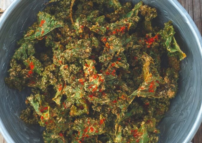 a bowl of savory kale chips with cashews, paprika, lemon, nutritional yeast