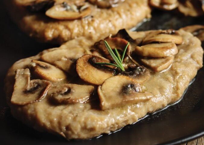 a close up of seitan fillets with mushroom wine sauce