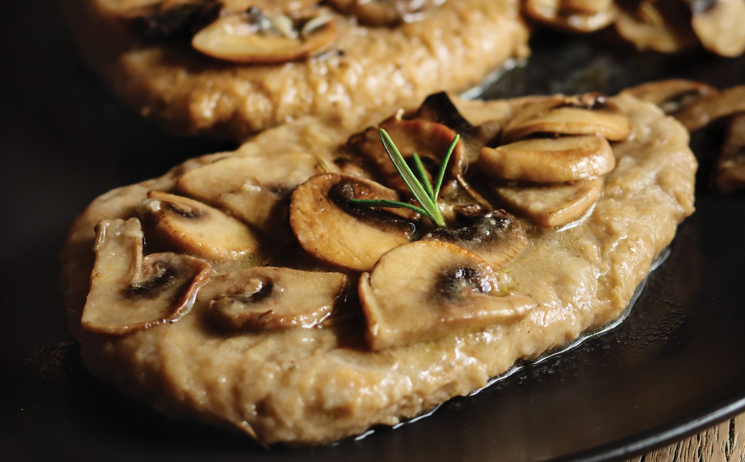 a close up of seitan fillets with mushroom wine sauce