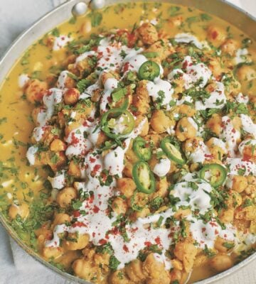 a pan of spicy chickpea curry with soya yogurt, fresh green chili, and chickpeas