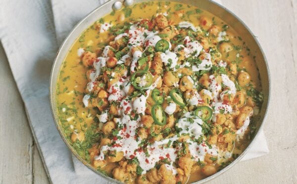 a pan of spicy chickpea curry with soya yogurt, fresh green chili, and chickpeas